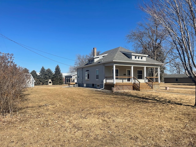 view of front of property featuring a porch, roof with shingles, and a front lawn