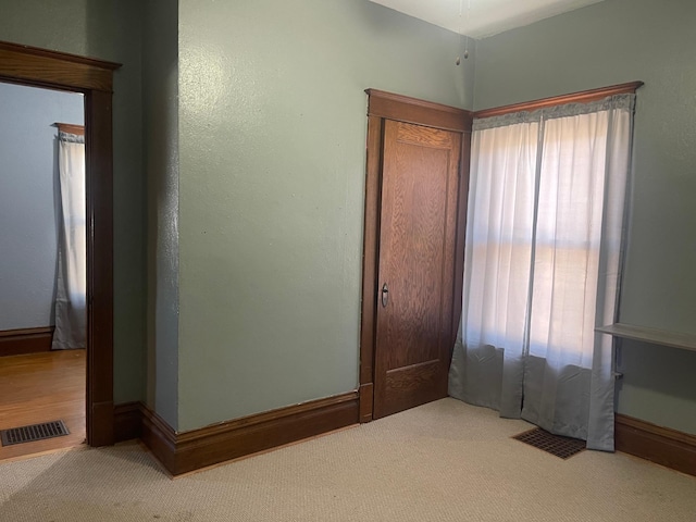 unfurnished bedroom featuring carpet, visible vents, and baseboards