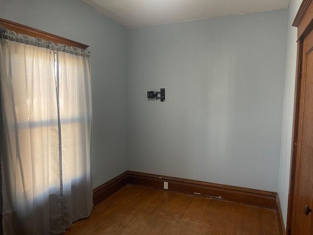 empty room with baseboards and wood finished floors