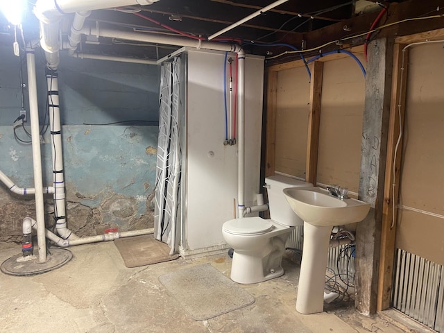 bathroom with toilet and unfinished concrete floors