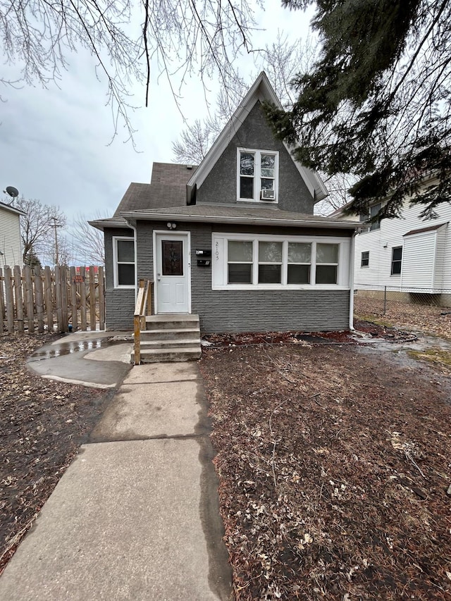 view of front of property featuring brick siding and fence