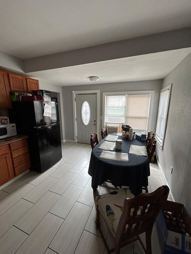 dining room with a textured wall and baseboards