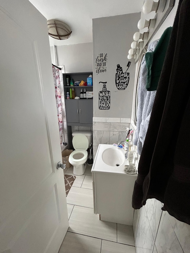 full bath featuring wainscoting, toilet, a shower with curtain, vanity, and tile walls