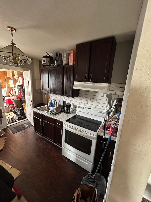 kitchen featuring electric range, tasteful backsplash, dark wood-style flooring, dark brown cabinets, and under cabinet range hood