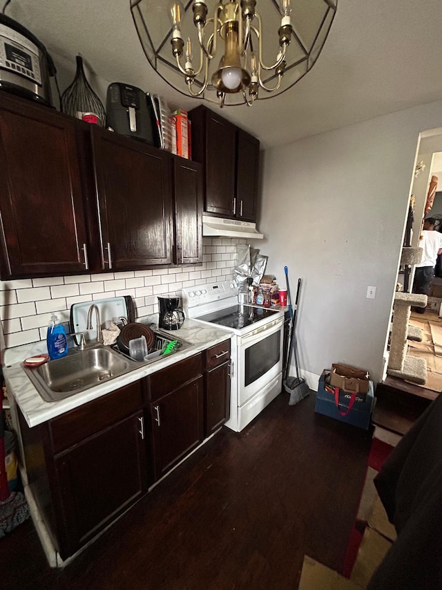 kitchen featuring white electric stove, light countertops, backsplash, a sink, and under cabinet range hood