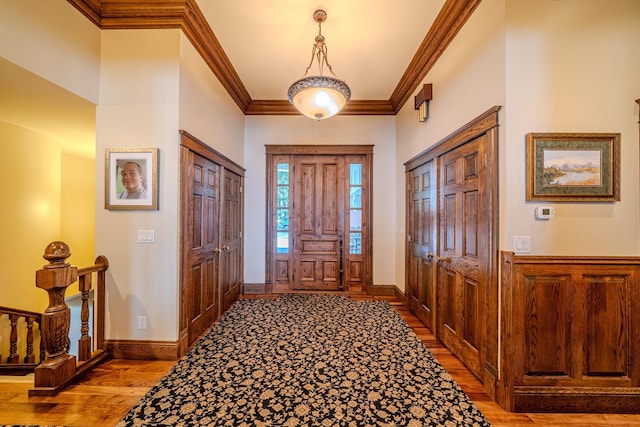 entrance foyer featuring baseboards, ornamental molding, and wood finished floors