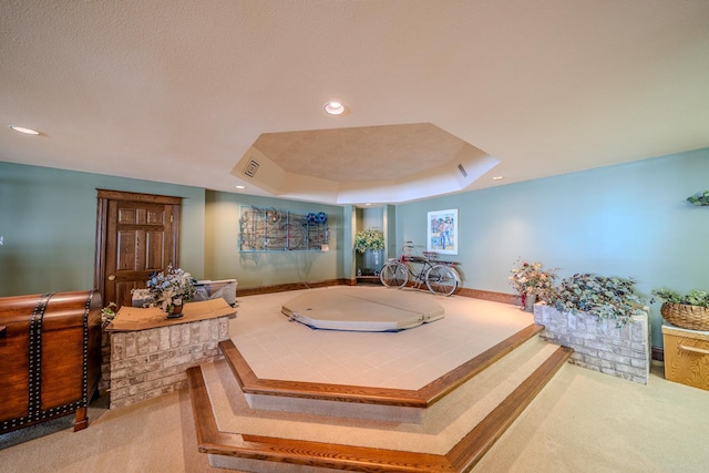 living area featuring carpet flooring, a raised ceiling, visible vents, and recessed lighting