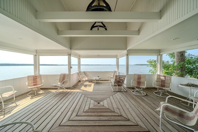 sunroom featuring beamed ceiling and a water view
