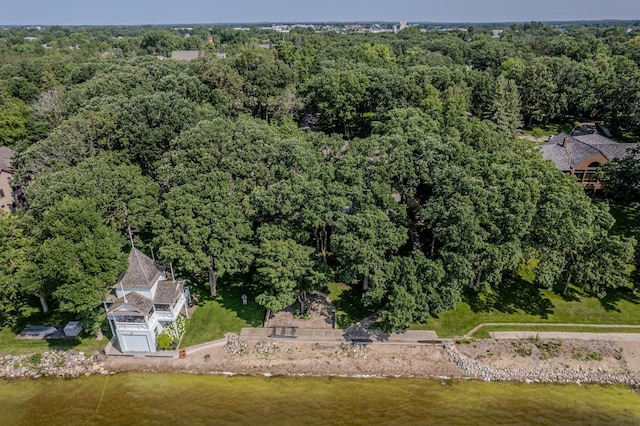 drone / aerial view featuring a water view and a wooded view