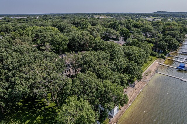birds eye view of property featuring a water view and a wooded view