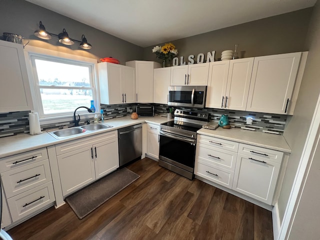 kitchen featuring white cabinetry, dark wood-style floors, appliances with stainless steel finishes, and a sink