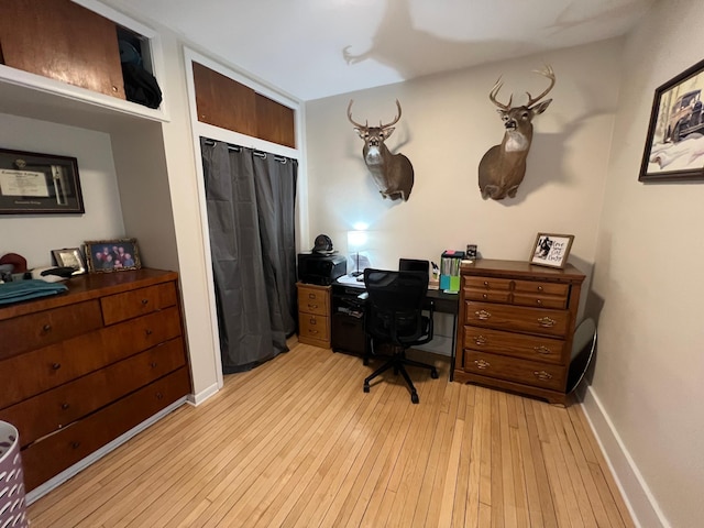 office space featuring baseboards and light wood-style flooring