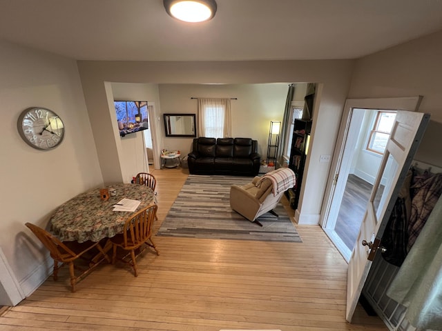 living room featuring a healthy amount of sunlight, baseboards, and light wood finished floors