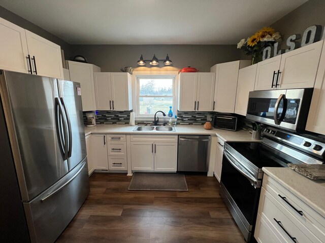 kitchen featuring tasteful backsplash, light countertops, appliances with stainless steel finishes, white cabinetry, and a sink