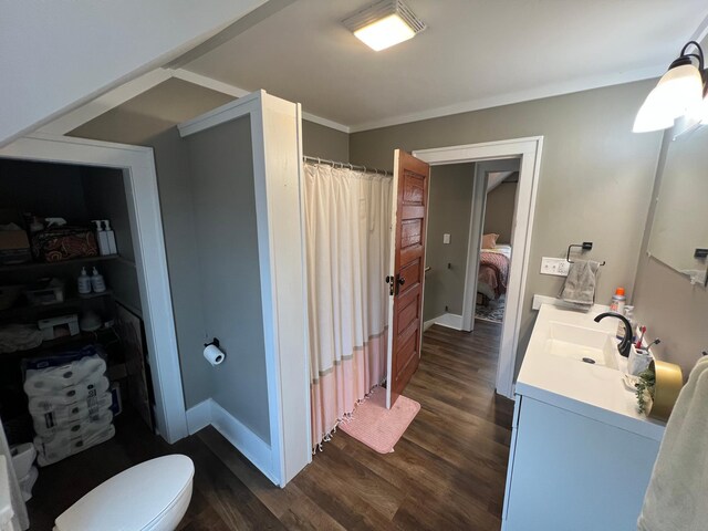 full bathroom with toilet, wood finished floors, crown molding, baseboards, and vanity