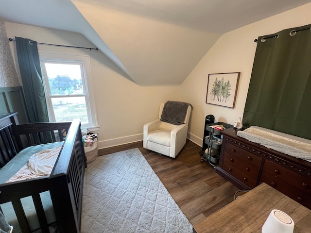 bedroom featuring lofted ceiling, wood finished floors, and baseboards