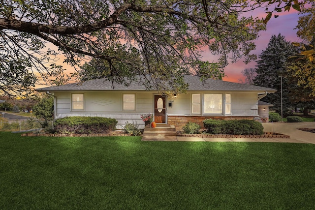 ranch-style home with brick siding and a lawn