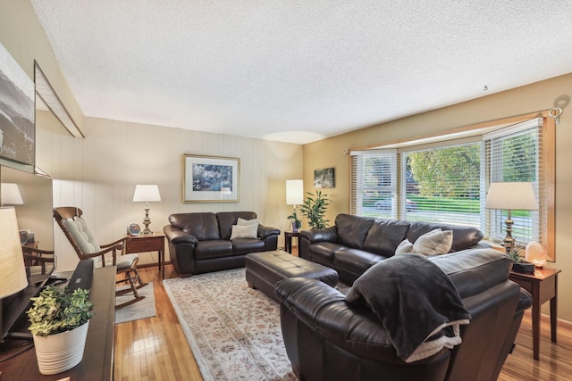 living area with a textured ceiling and wood finished floors