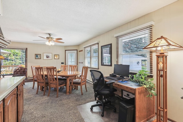 office area featuring a ceiling fan, carpet, a healthy amount of sunlight, and a textured ceiling