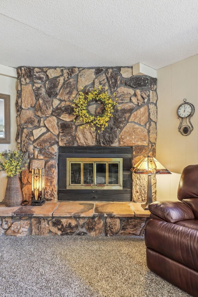 carpeted living room featuring a textured ceiling and a stone fireplace