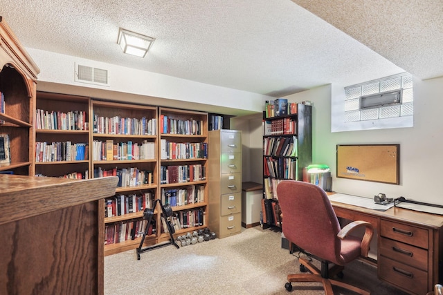 office space with carpet floors, visible vents, and a textured ceiling