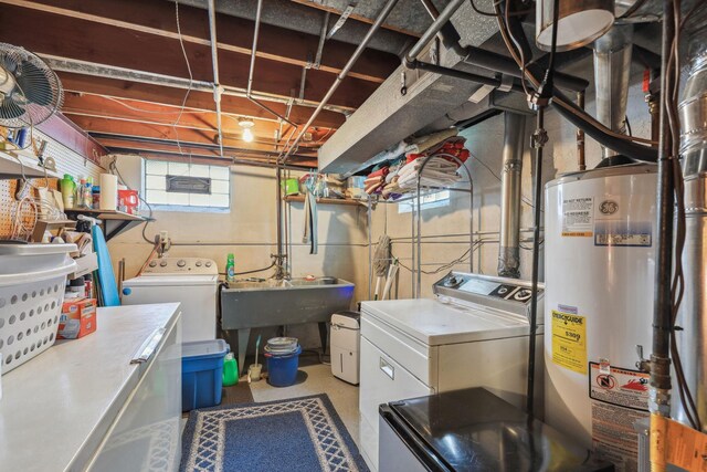 laundry room with water heater, laundry area, washer and clothes dryer, and a sink