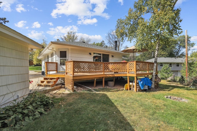 rear view of house with a yard and a deck