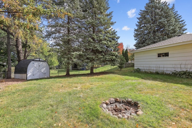 view of yard with a storage unit, fence, and an outbuilding