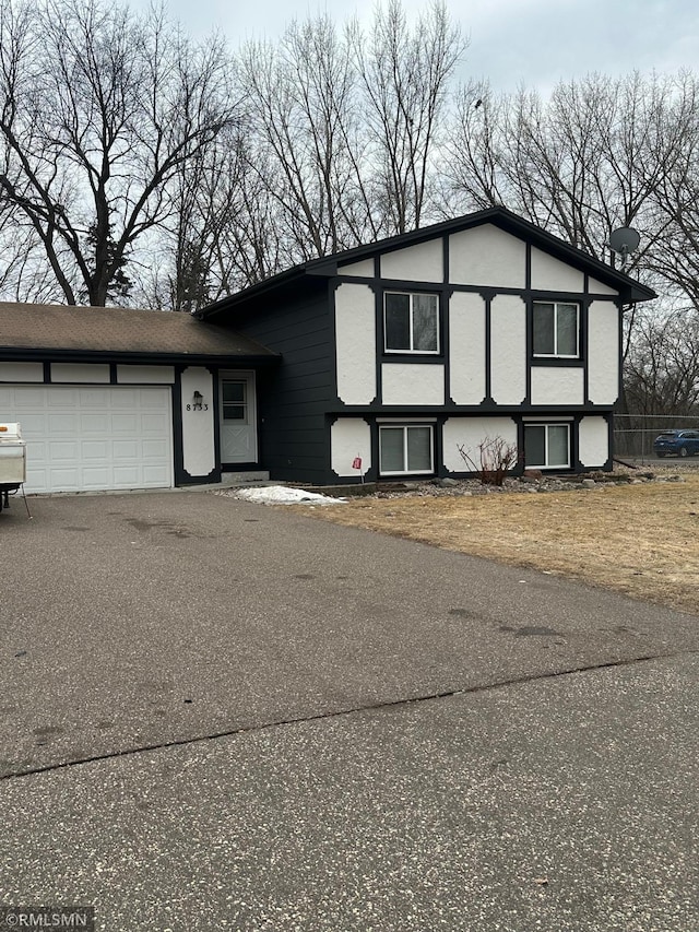 view of front facade with driveway, an attached garage, and stucco siding