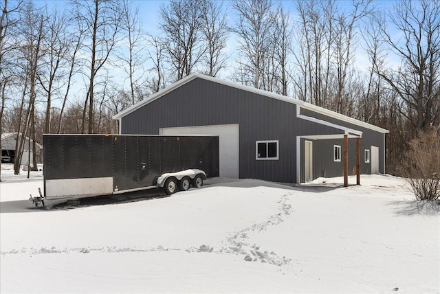 snow covered garage featuring a detached garage