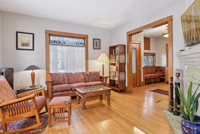 living room with light wood finished floors and a fireplace with flush hearth