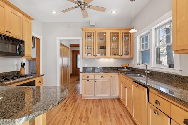 kitchen with a sink, stainless steel gas stovetop, black microwave, light wood finished floors, and dishwasher