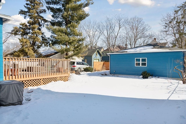 snow covered rear of property with a wooden deck