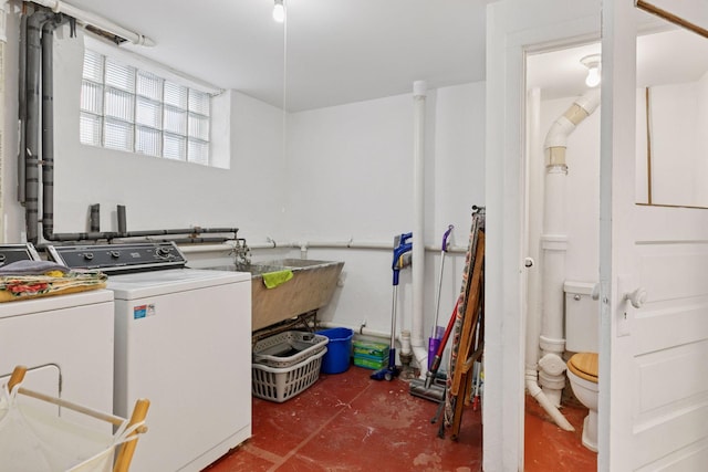 washroom with a sink, laundry area, and washing machine and clothes dryer