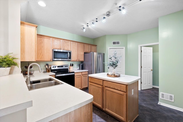 kitchen with light countertops, appliances with stainless steel finishes, a sink, and visible vents