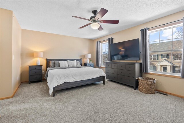 bedroom featuring baseboards, a textured ceiling, visible vents, and carpet flooring