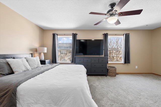 bedroom with carpet floors, ceiling fan, baseboards, and a textured ceiling