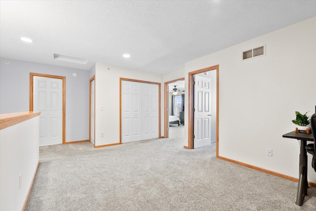 unfurnished bedroom featuring light carpet, baseboards, visible vents, and recessed lighting