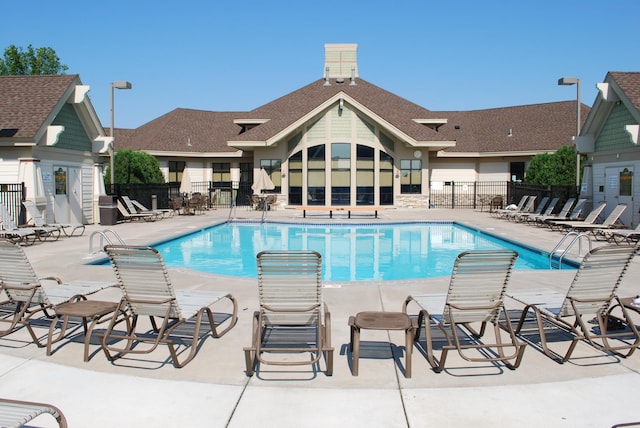 pool featuring fence and a patio