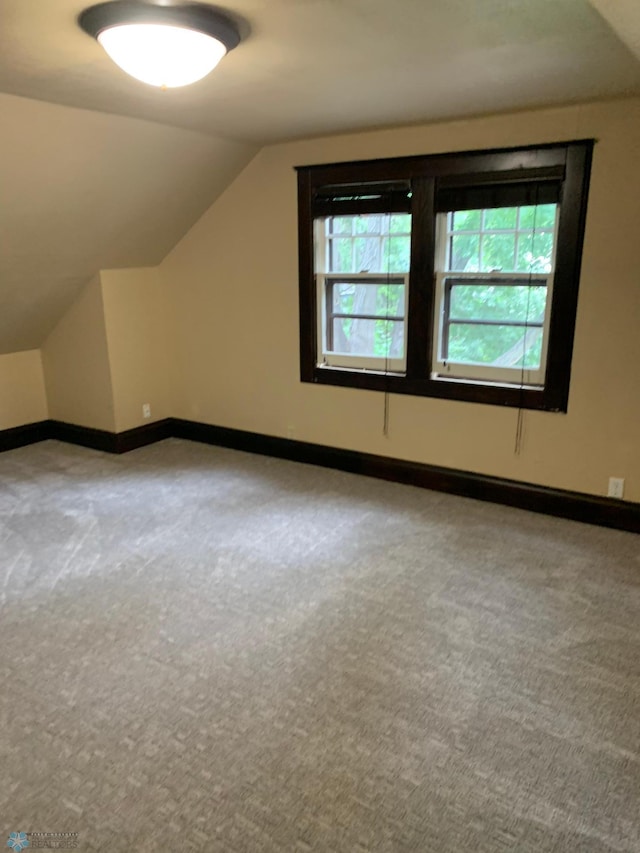 bonus room with lofted ceiling, carpet, and baseboards