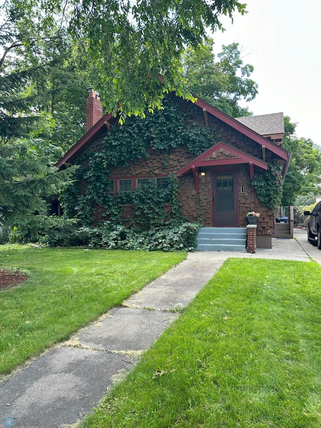 view of front facade featuring a chimney and a front lawn