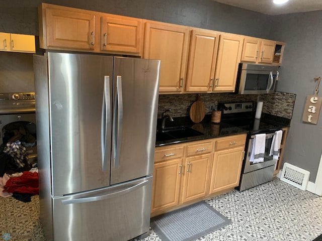 kitchen with tasteful backsplash, visible vents, stainless steel appliances, and a sink