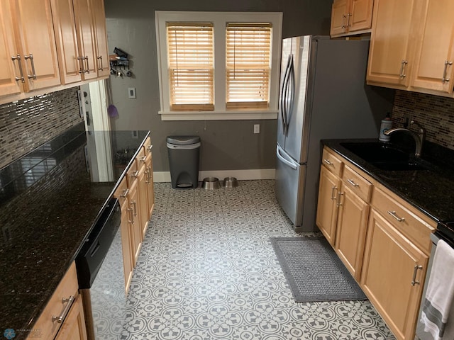 kitchen with a sink, baseboards, dishwasher, tasteful backsplash, and dark stone countertops