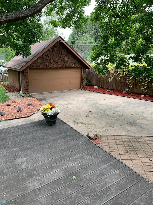 view of front of home with stone siding, fence, and concrete driveway