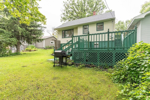 back of house featuring a deck, roof with shingles, a lawn, and a chimney