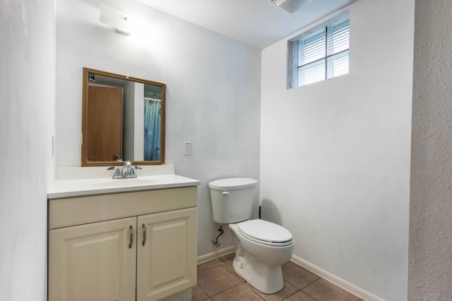 bathroom featuring tile patterned flooring, baseboards, vanity, and toilet