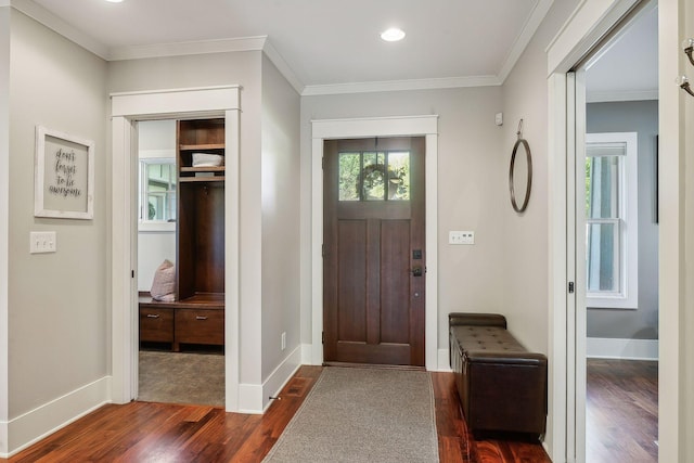foyer entrance featuring recessed lighting, ornamental molding, dark wood finished floors, and baseboards