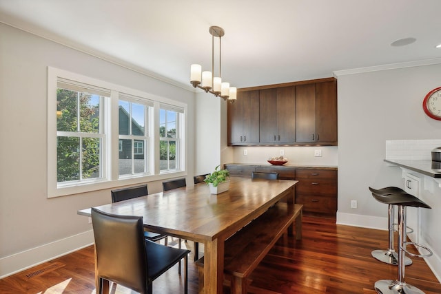 dining room with crown molding, visible vents, baseboards, and dark wood-type flooring
