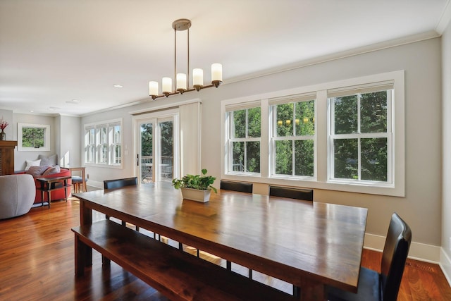 dining area featuring crown molding, baseboards, wood finished floors, and a healthy amount of sunlight