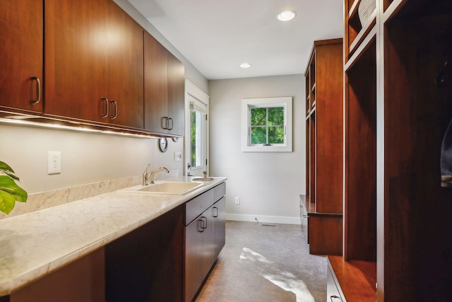 interior space with recessed lighting, light countertops, a sink, baseboards, and visible vents